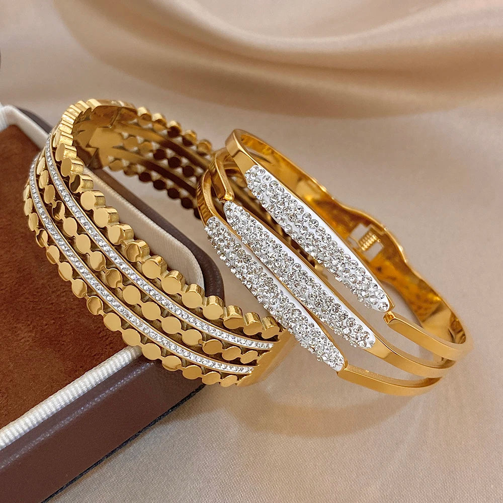 Gold-tone wide cuff bangle with rhinestone inlaid stripes and raised geometric link trim