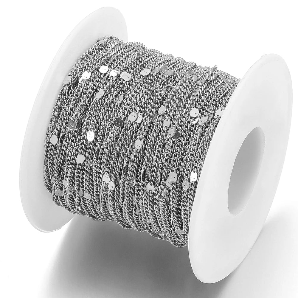Silver textured flat oval chain on white spool, round link centers