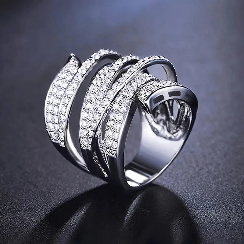 Wide cubic zirconia pave irregular band ring with curved metal rows, silver tone.