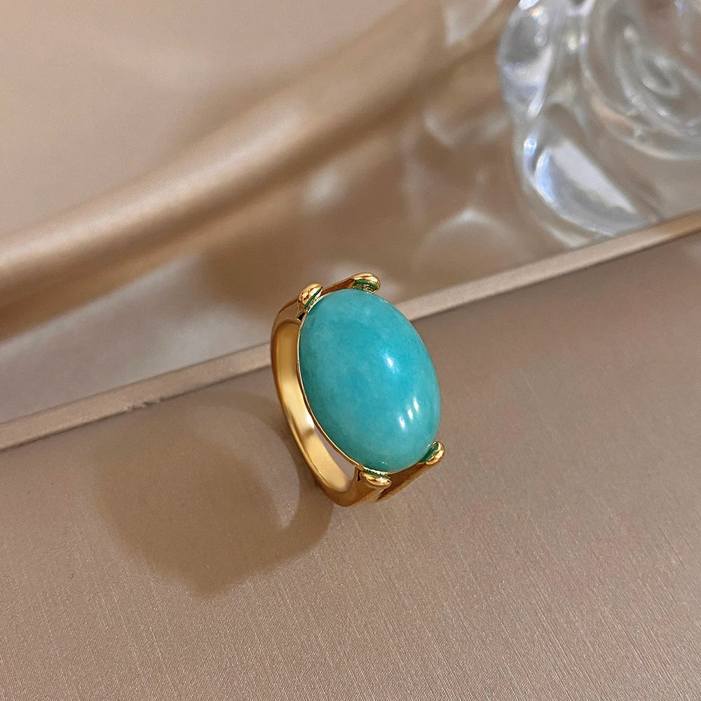 Gold-tone turquoise oval stone ring with curved open-style band