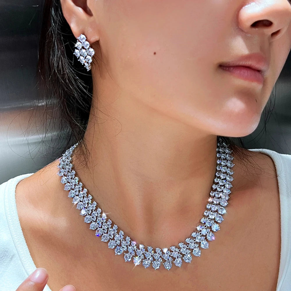 Silver-tone CZ cluster necklace and square stud earrings on model, neckline close-up