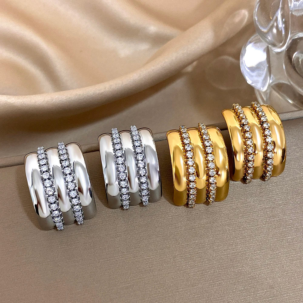 Gold- and silver-tone ridged stud earrings with twin rhinestone rows, shown in two finishes