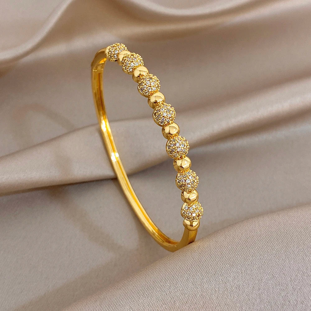 Gold-plated cuff bangle with round zircon ball beads along the band
