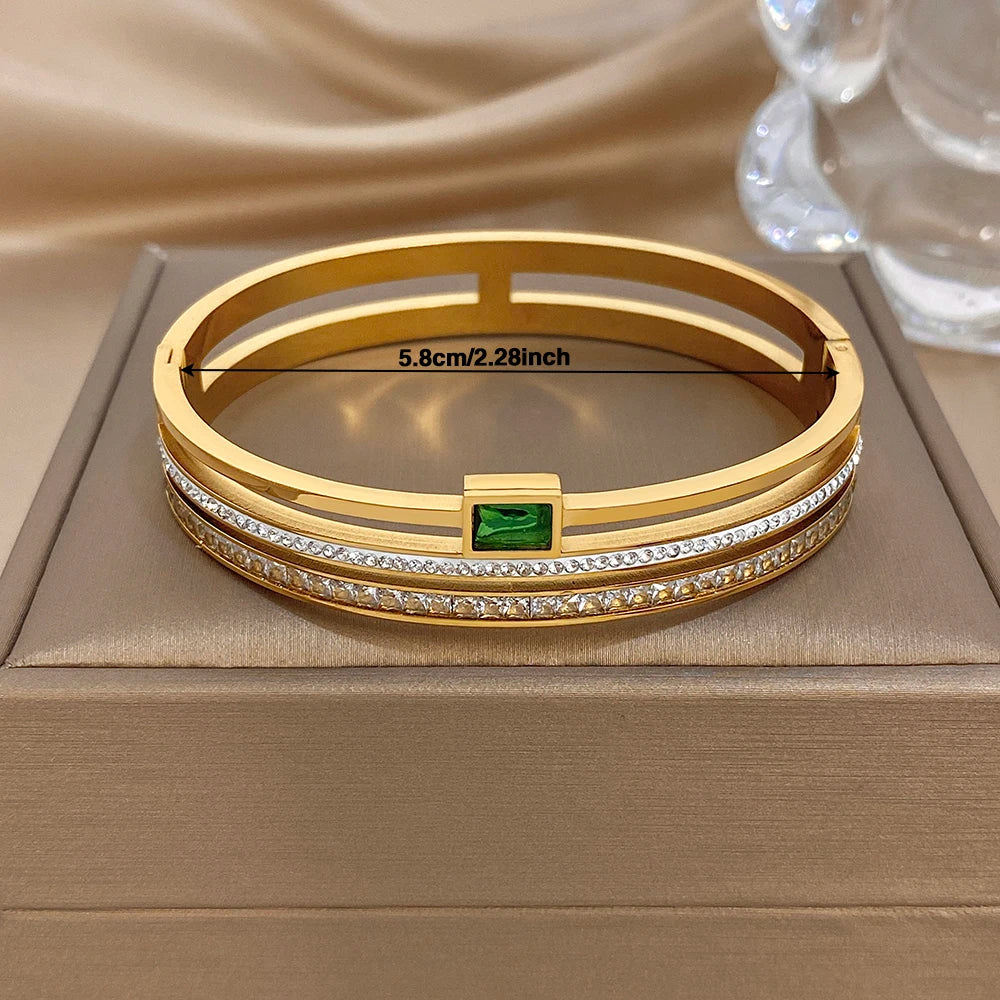 Gold stainless steel cuff bracelet with green center stone and white zircon accents