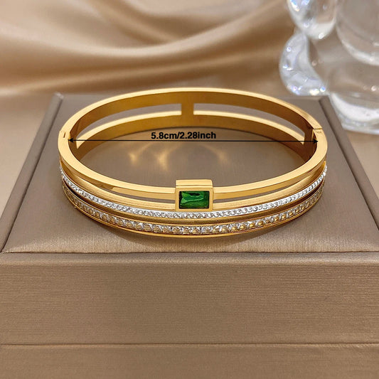 Gold stainless steel cuff bracelet with green center stone and white zircon accents