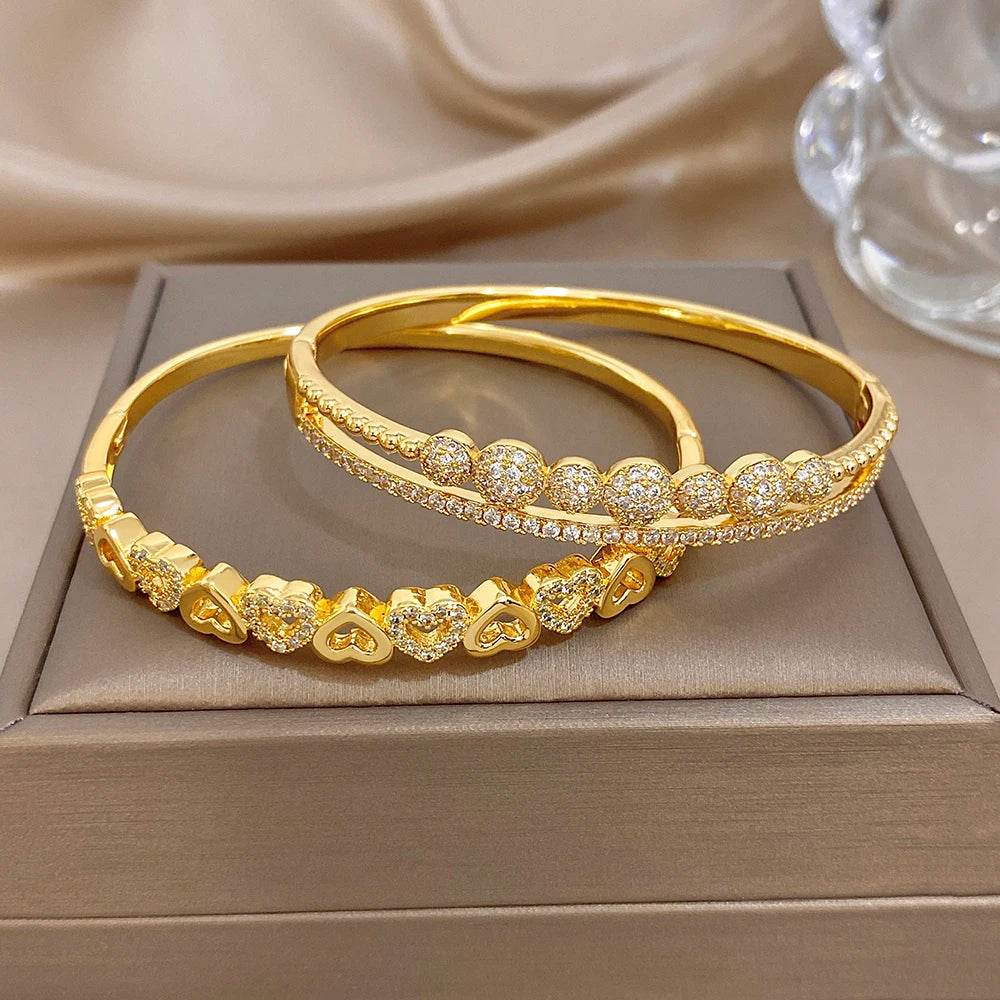 Gold-tone cuff bangles with heart and round zircon accents