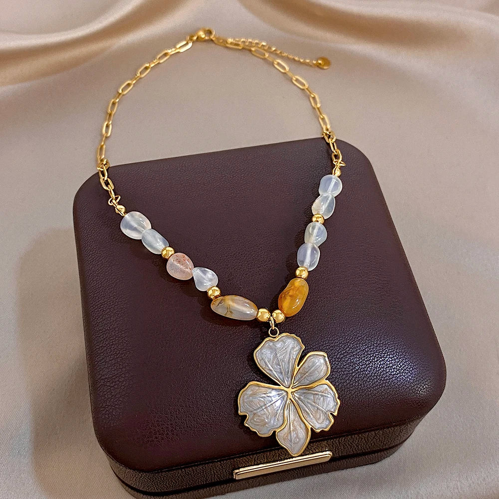 Gold plated necklace with light and amber beads and white enamel flower pendant