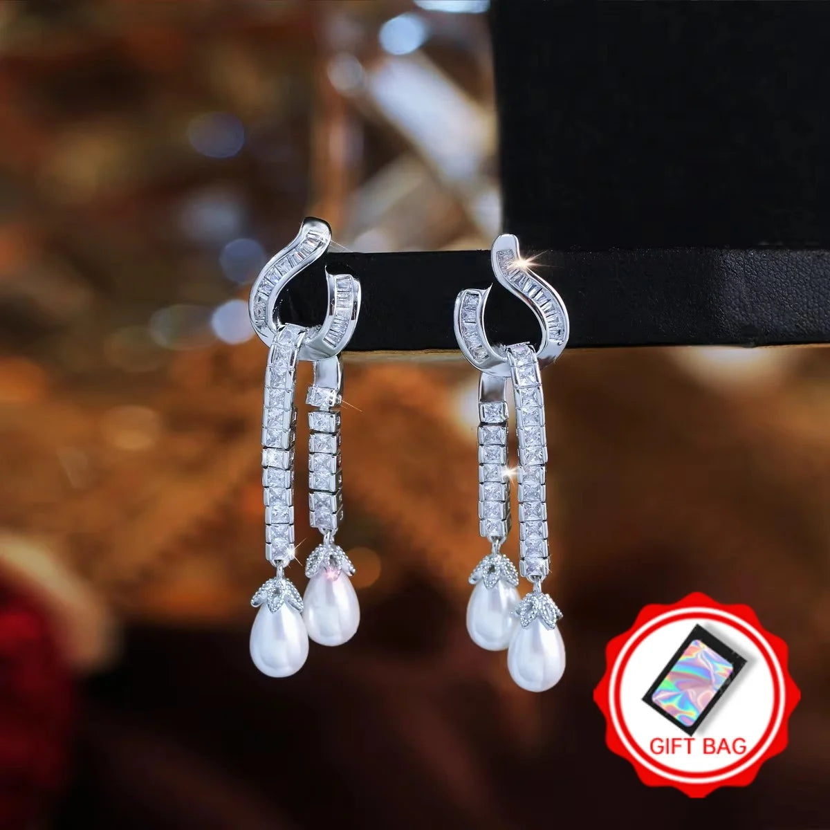 Pair of zirconia and pearl dangle earrings with a gift bag included.