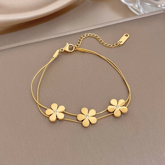 Gold double-layer snake chain bracelet with five flower charms and crystal centers