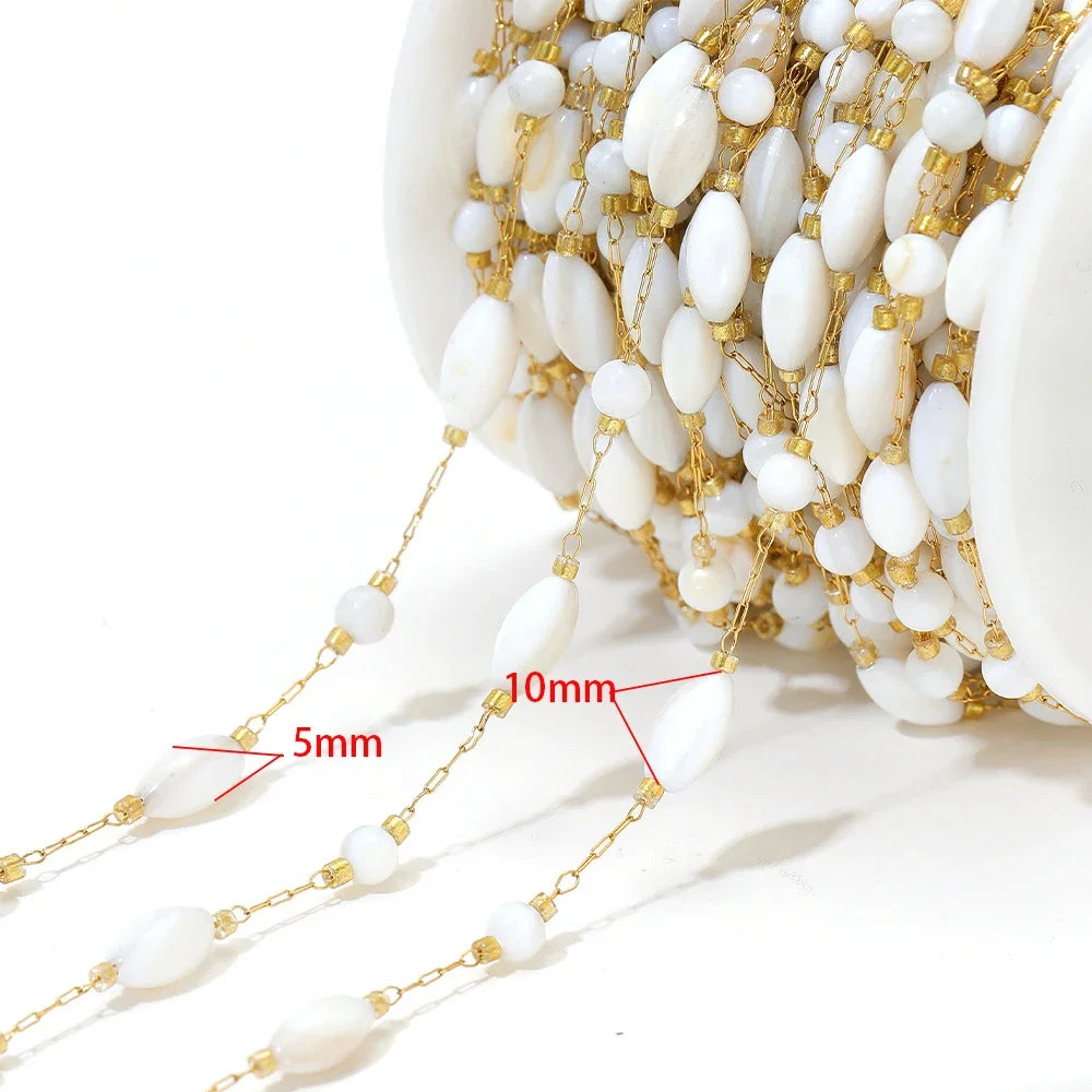 Close-up of hanging white shell-style bead chains with gold-tone connector links