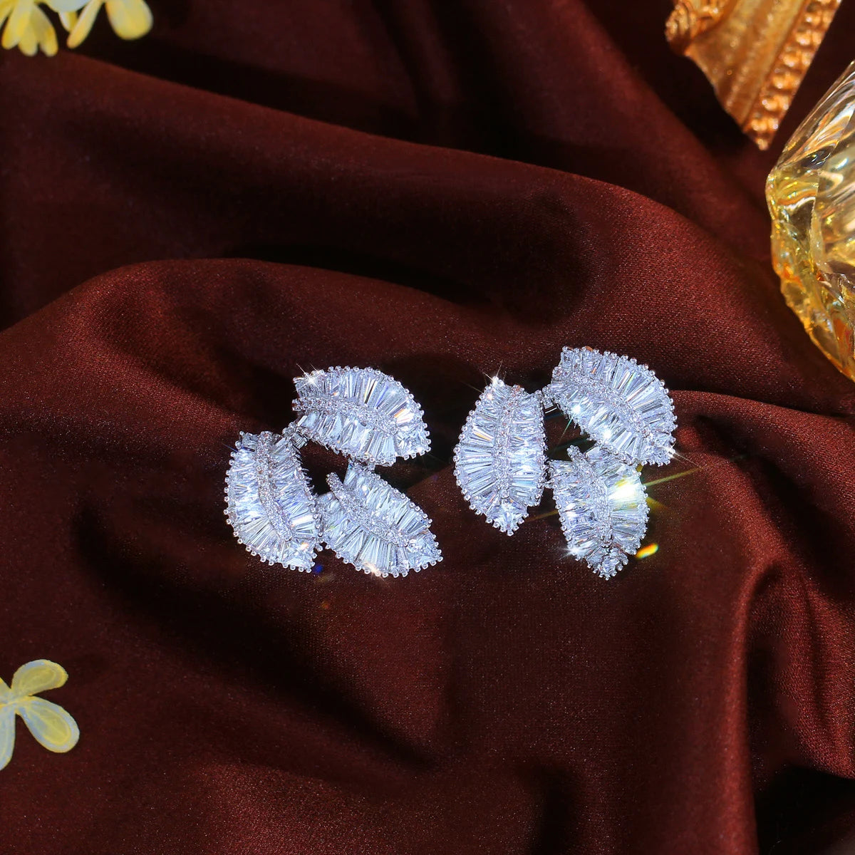 Leaf cubic zirconia dangle earrings in shiny white metal, pair
