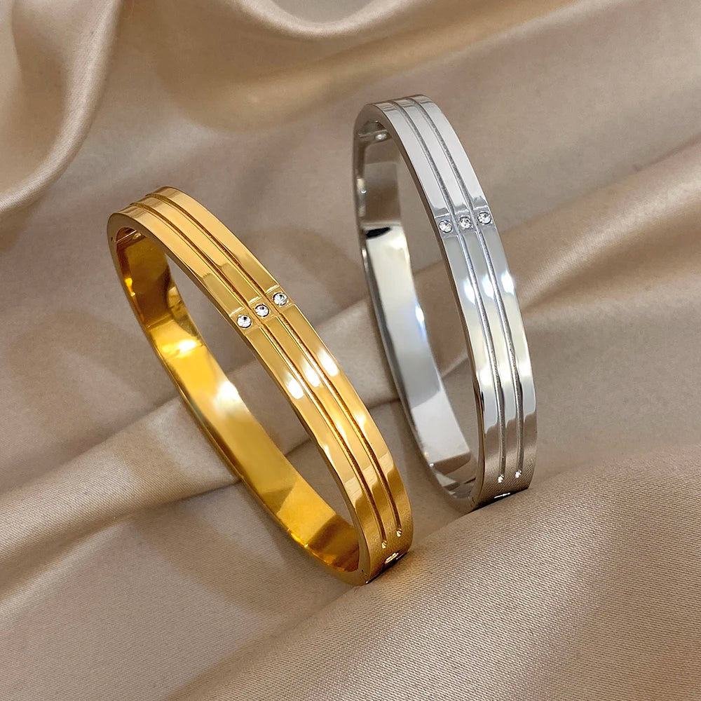 Gold-tone stainless steel wide cuff bangle with crystal stud accents