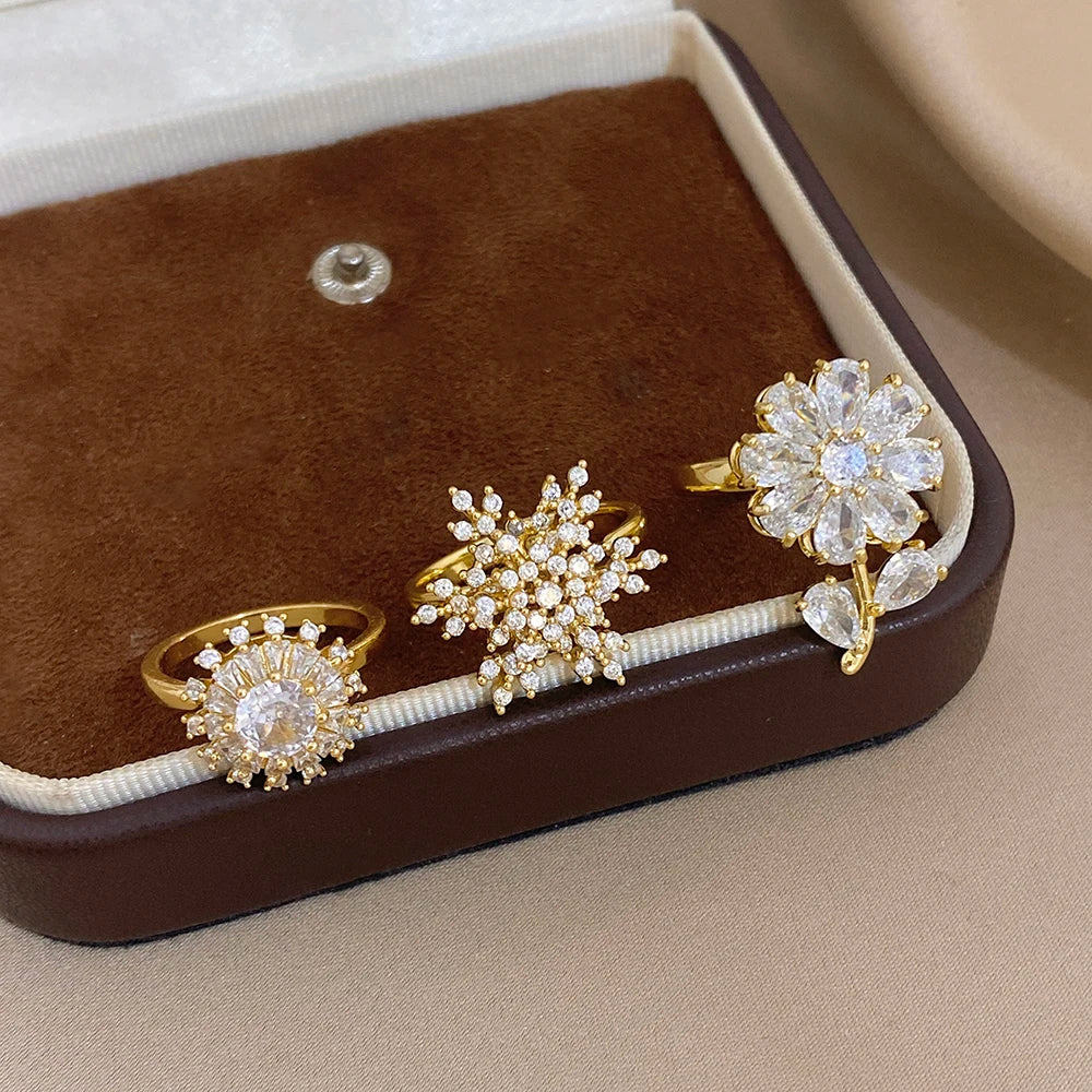 Gold-plated copper flower zirconia rings in a box, clear stones with gold bands
