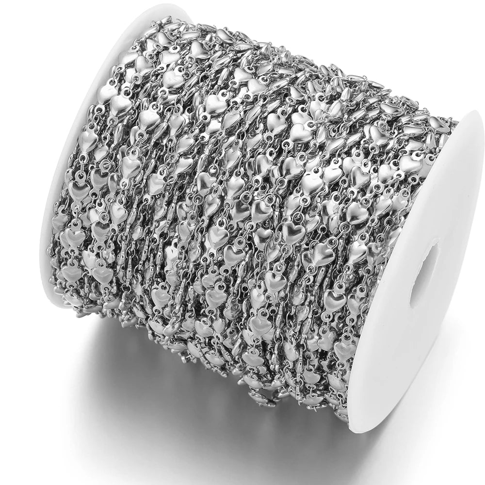 Silver heart chain wound on a spool, featuring repeating small heart links