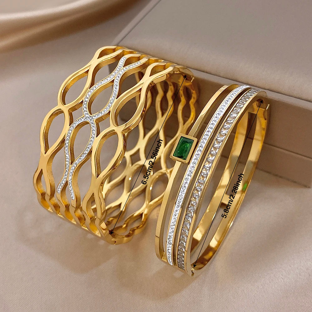 Gold-tone geometric cuff with oval-cut clear stones, rhinestone bands, and green square inset