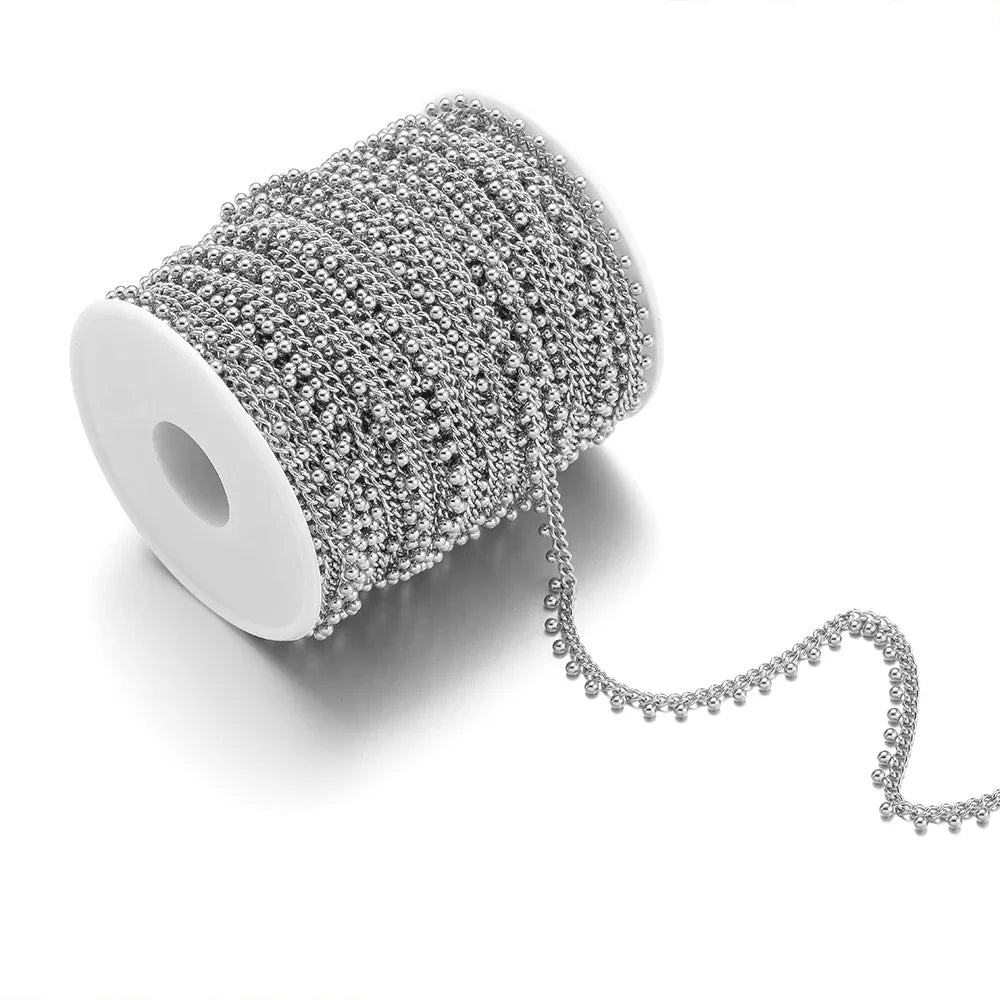 Silver beaded curb link chain on spool, with small ball drop chain strand