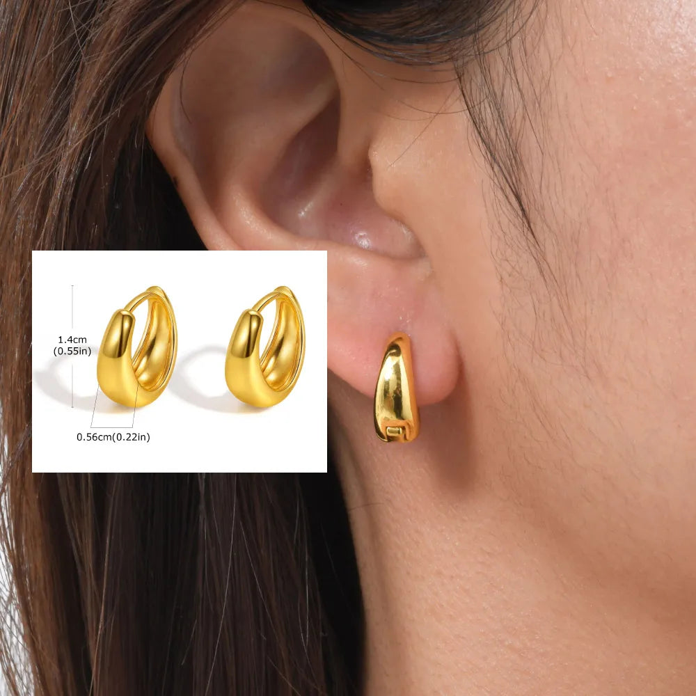 Small polished gold-tone huggie hoop earrings with a rounded, thick profile.