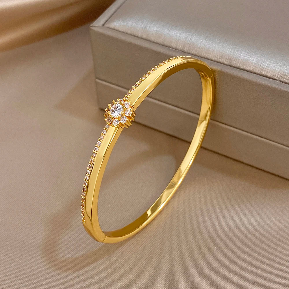 Gold-plated cuff bangle with zircon flower accent and halo of micro stones