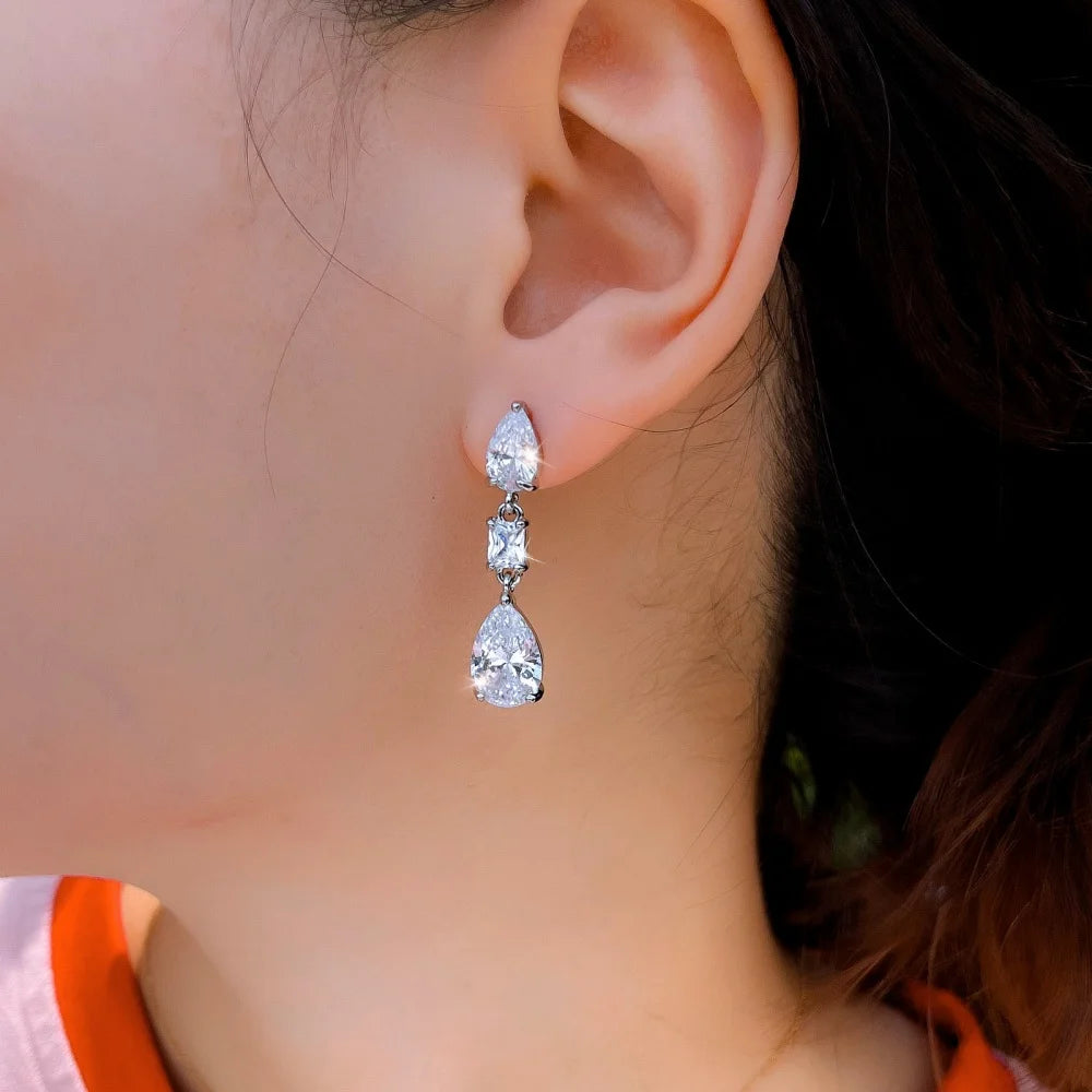 Single crystal teardrop earring shown worn, with three linked stones.