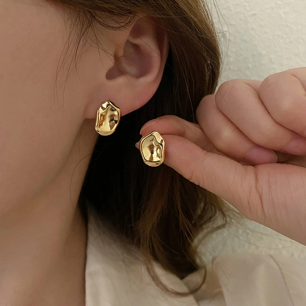 Geometric gold-tone post stud earrings with raised oval-shaped fronts