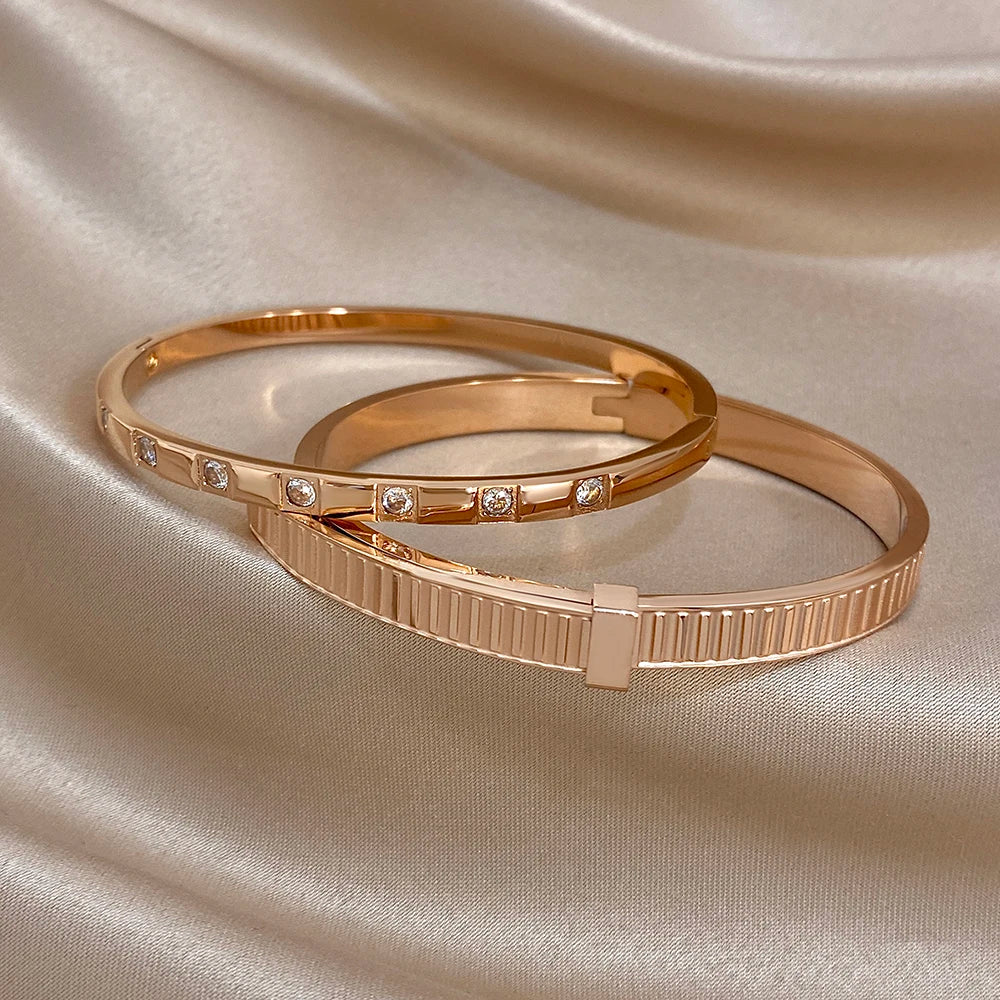 Rose gold cuff bangles with clear stones and a ribbed geometric closure panel
