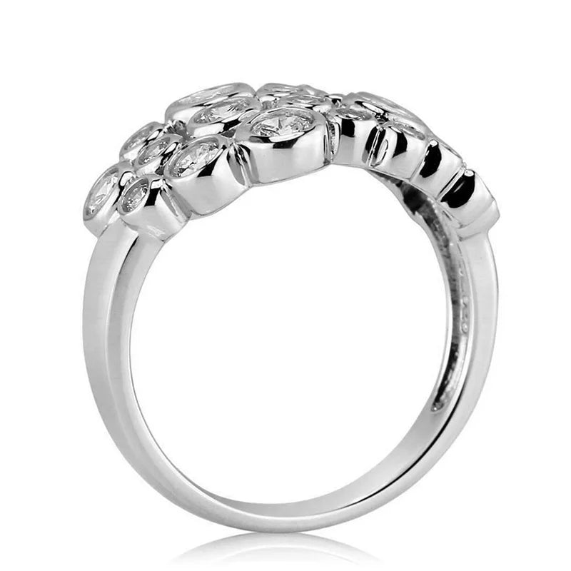 Silver-toned ring band with glossy prongs holding round cubic zirconia stones