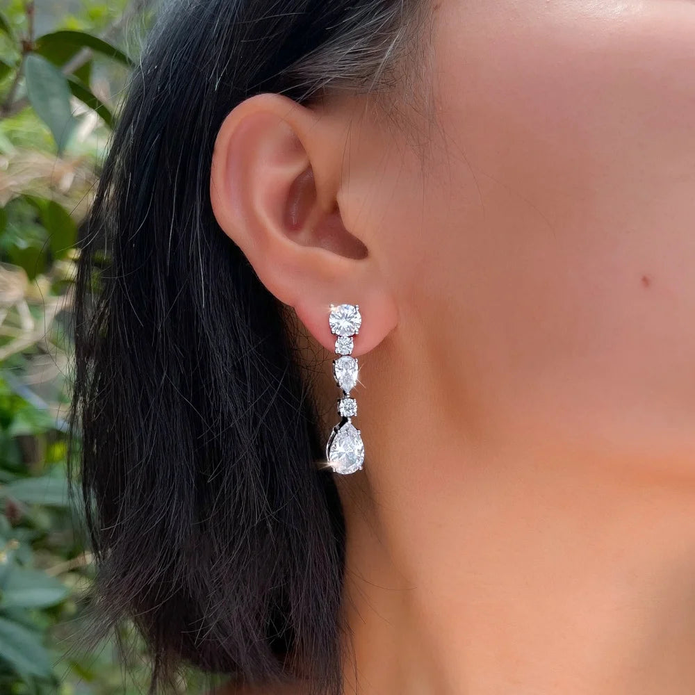 Cubic zirconia dangle earring with a round stud and pear-shaped drop, shown worn.
