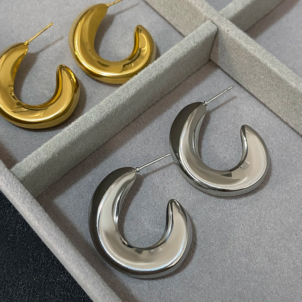 Gold- and silver-tone chunky hoop earrings with glossy crescent-shaped profiles