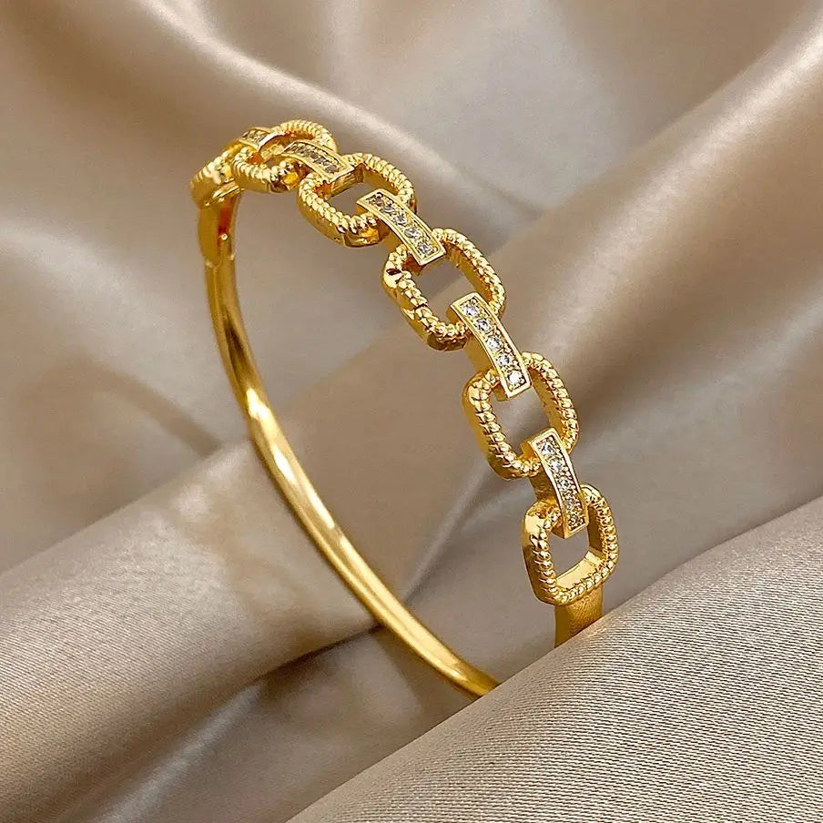 Gold-tone geometric square-link cuff bracelet with clear zircon accents and hinge clasp