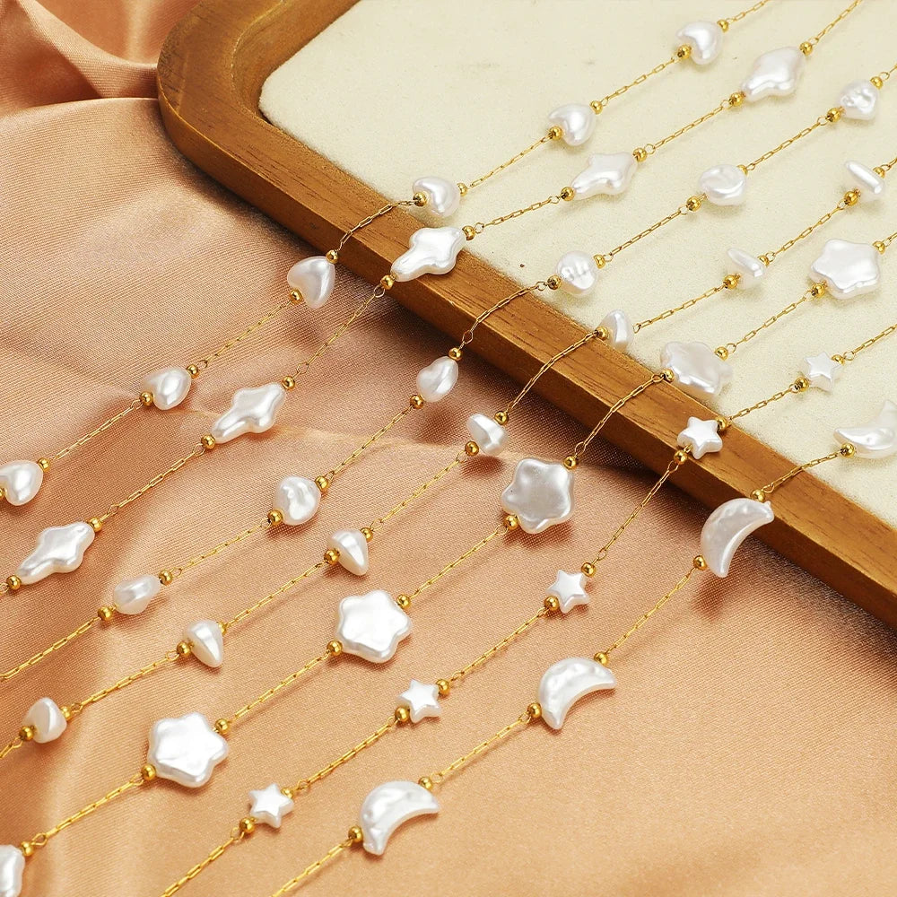 Gold-tone chain with white artificial pearls and small charm links, bundled on wooden bar