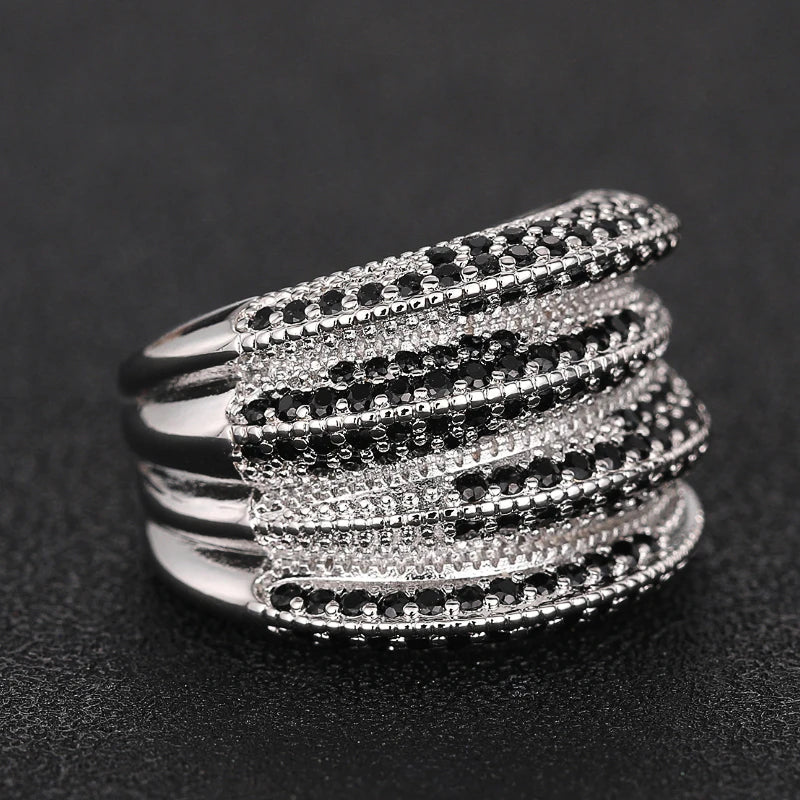 Wide silver-tone ring with layered ridges and rows of black and clear stones