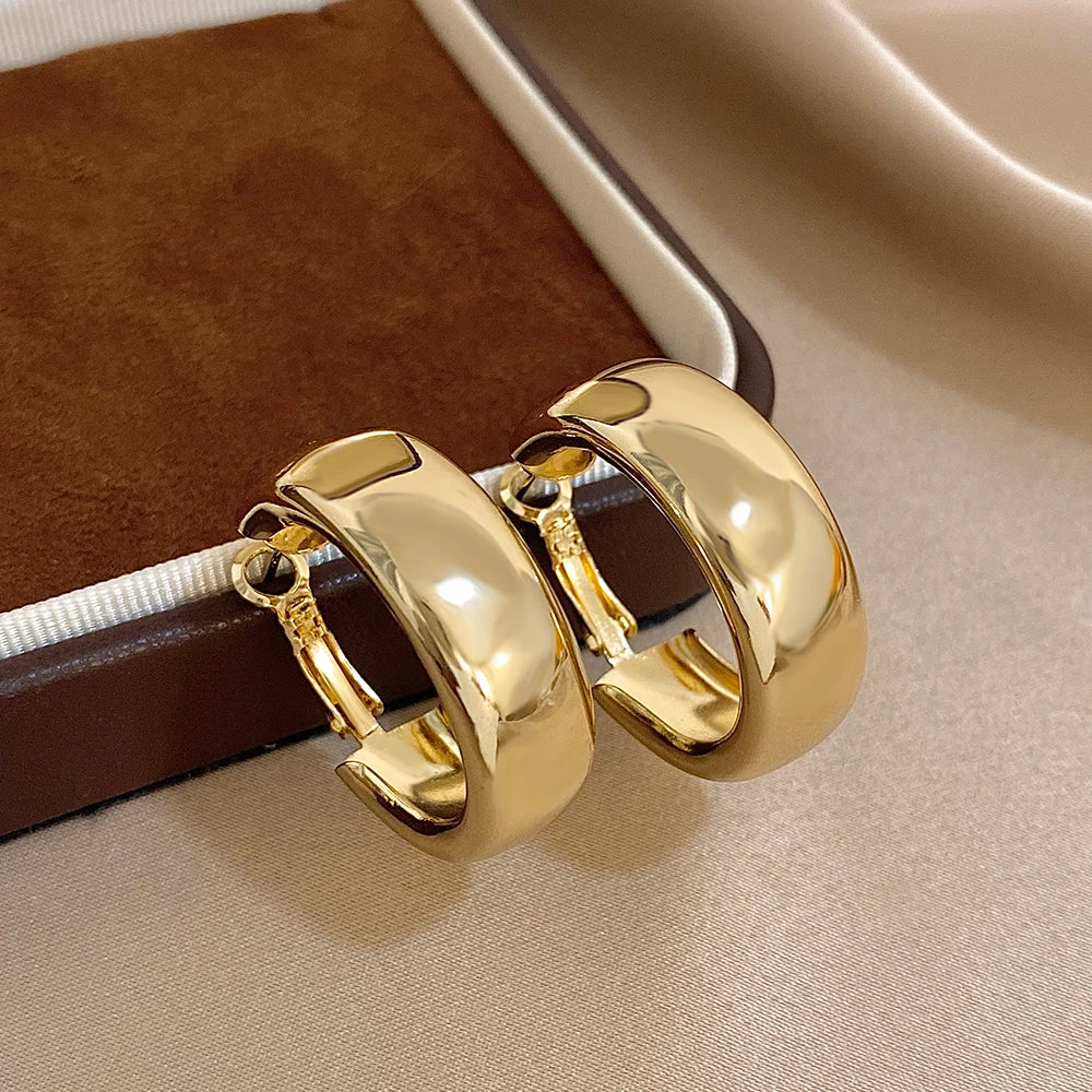 Pair of polished gold-tone wide hoop earrings with hinged clasps