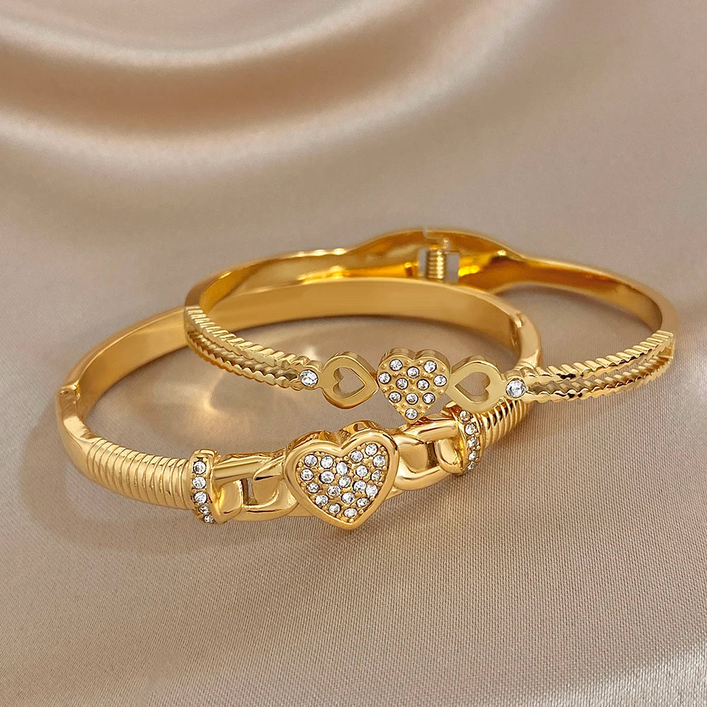 Gold-tone twisted knot heart cuff bangle with rhinestone accents and braided details