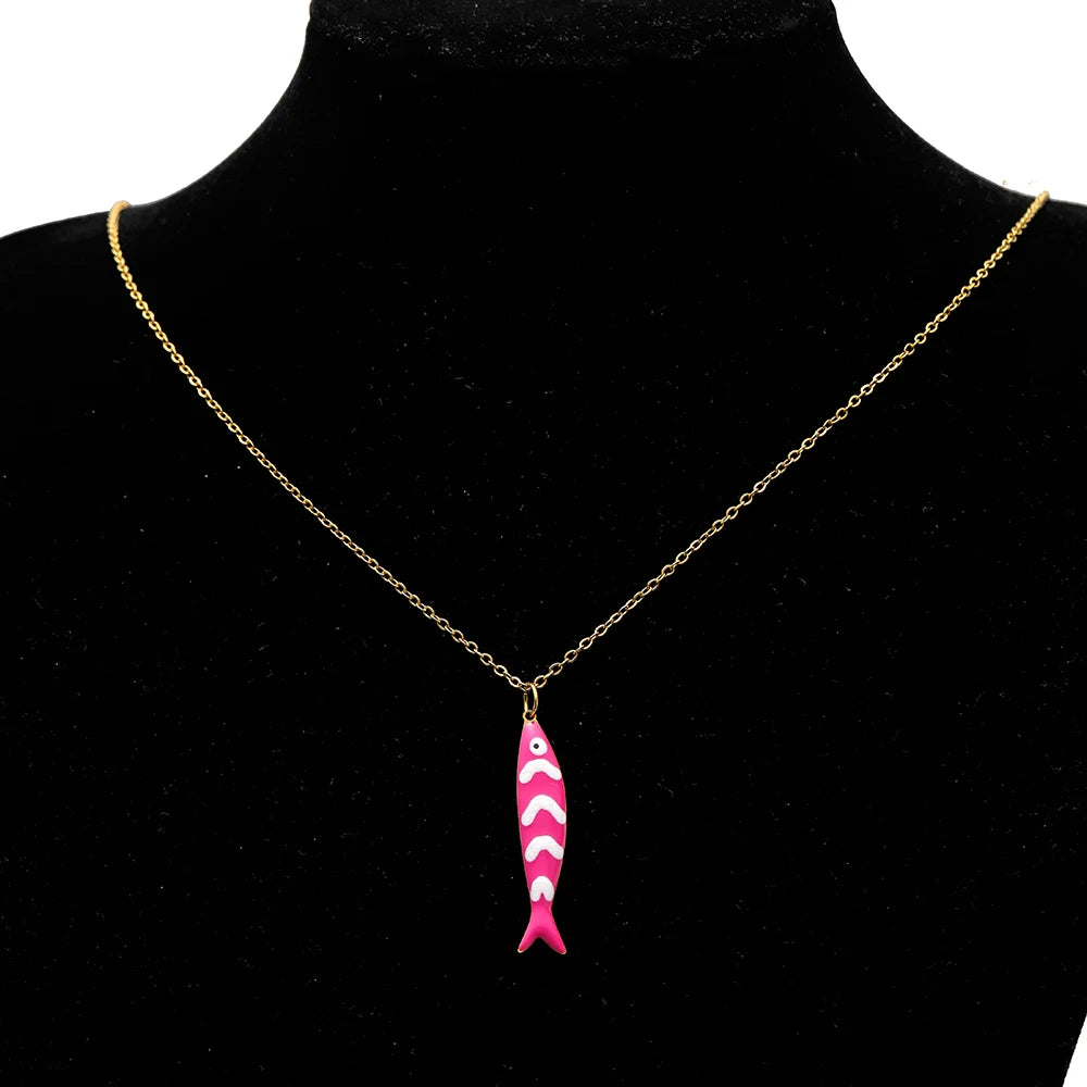 Pink enamel fish charm pendant on a gold-tone necklace chain