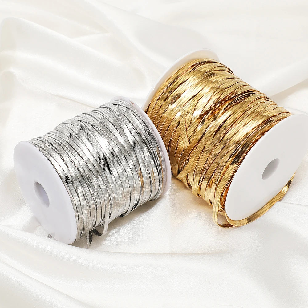 Flat snake chain cords on two spools, gold and silver, for DIY jewelry making