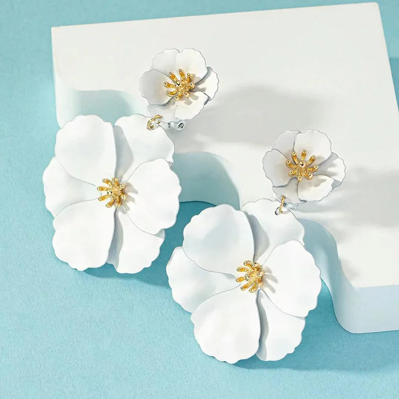White double floral drop earrings set with gold-tone centers