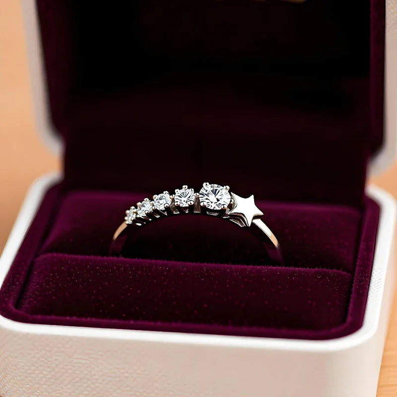 Silver-tone CZ ring with star top and sparkling row of stones in a jewelry box