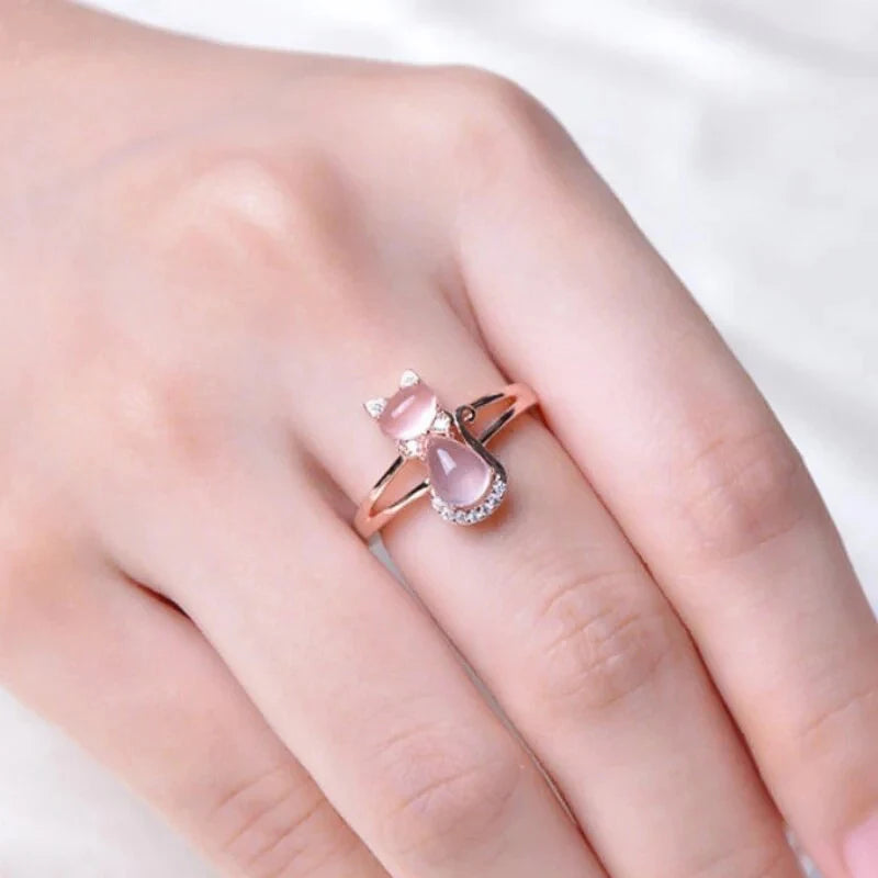 Rose gold pink cat ring on hand, double-band design with oval pink stones