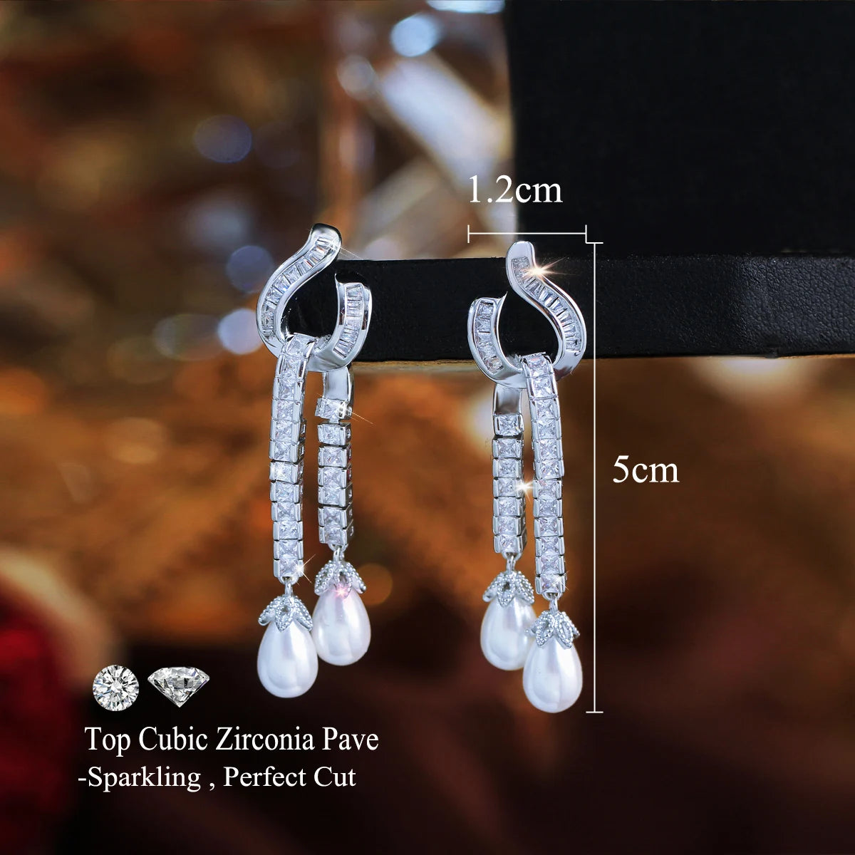 Pair of zirconia and pearl dangle earrings, shown with 5 cm length and 1.2 cm width.