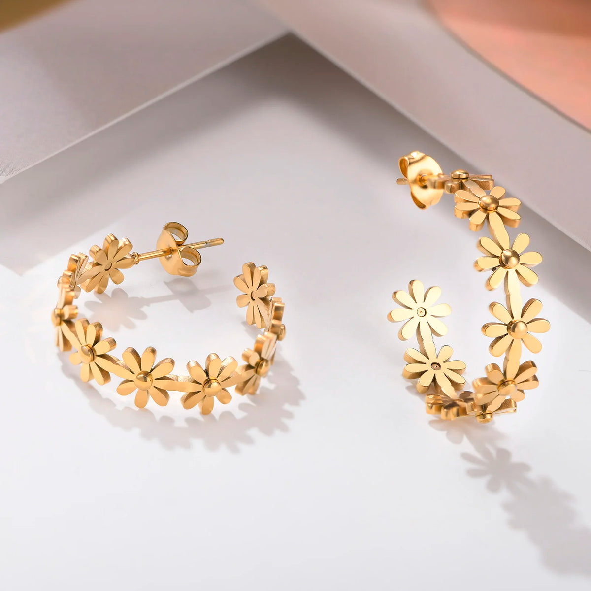 Daisy flower hoop earrings in gold tone with small floral charms and stud posts