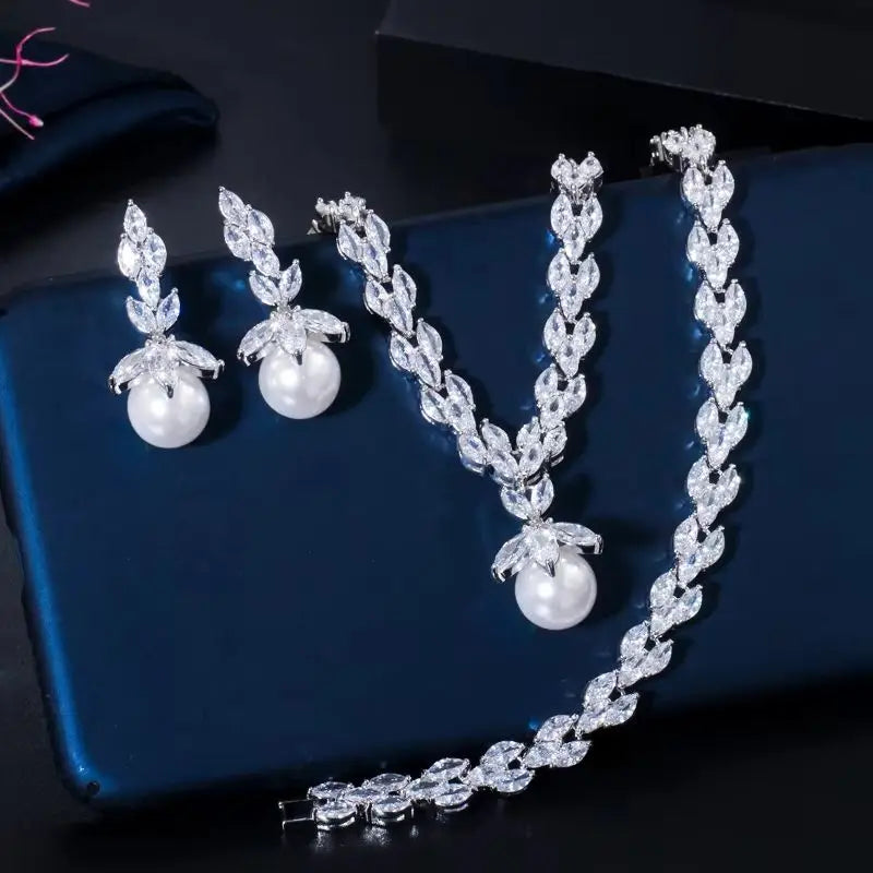 Crystal leaf necklace, pearl drop earrings, and matching bracelet shown individually