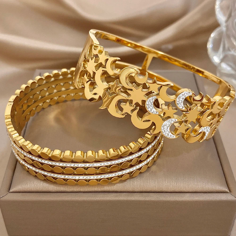 Stack of gold-tone wide cuff bangles with beaded edges and star-moon crystal insets