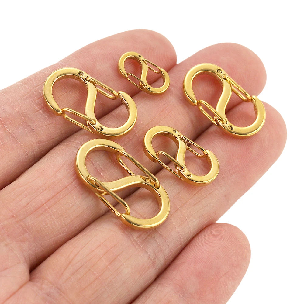 Gold-tone spring lobster clasps held in palm, small connector for DIY jewelry