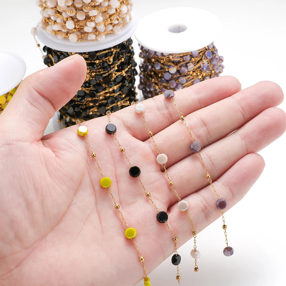 Assorted crystal bead chains with gold links shown in an open hand for DIY crafts