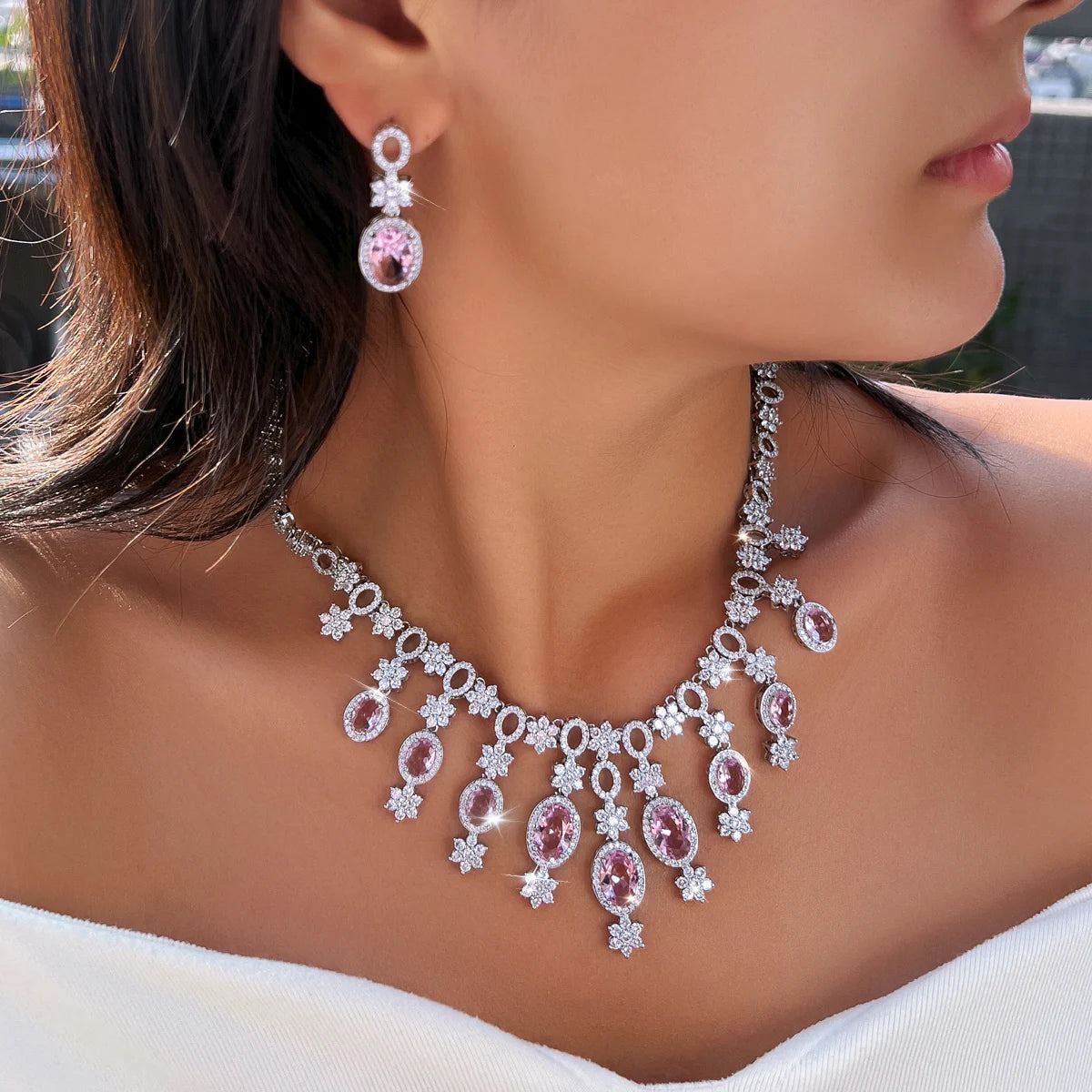 Silver-tone necklace and drop earrings with pink oval stones and floral crystal accents, worn together
