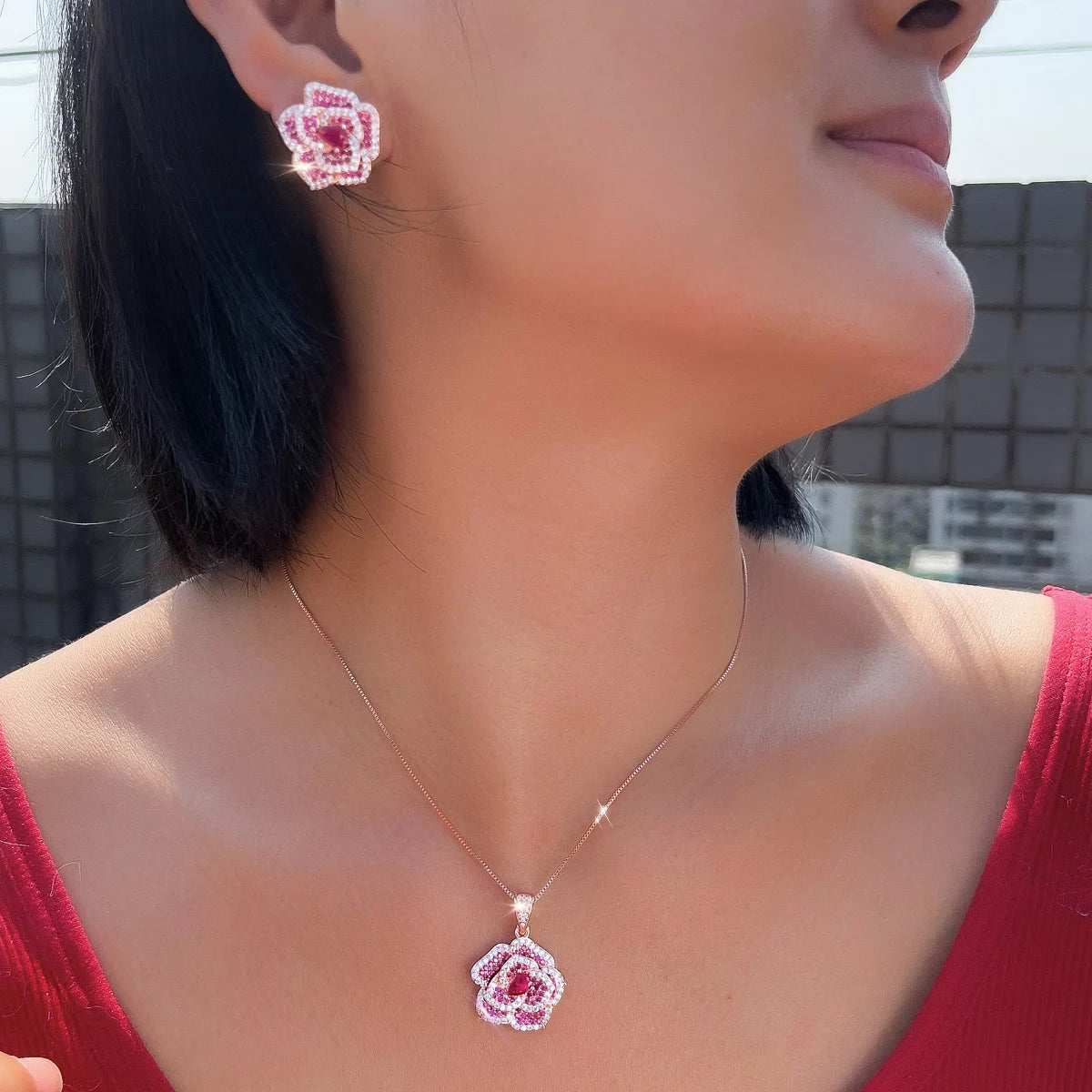 Rose-red flower pendant necklace and matching CZ earring worn on a model