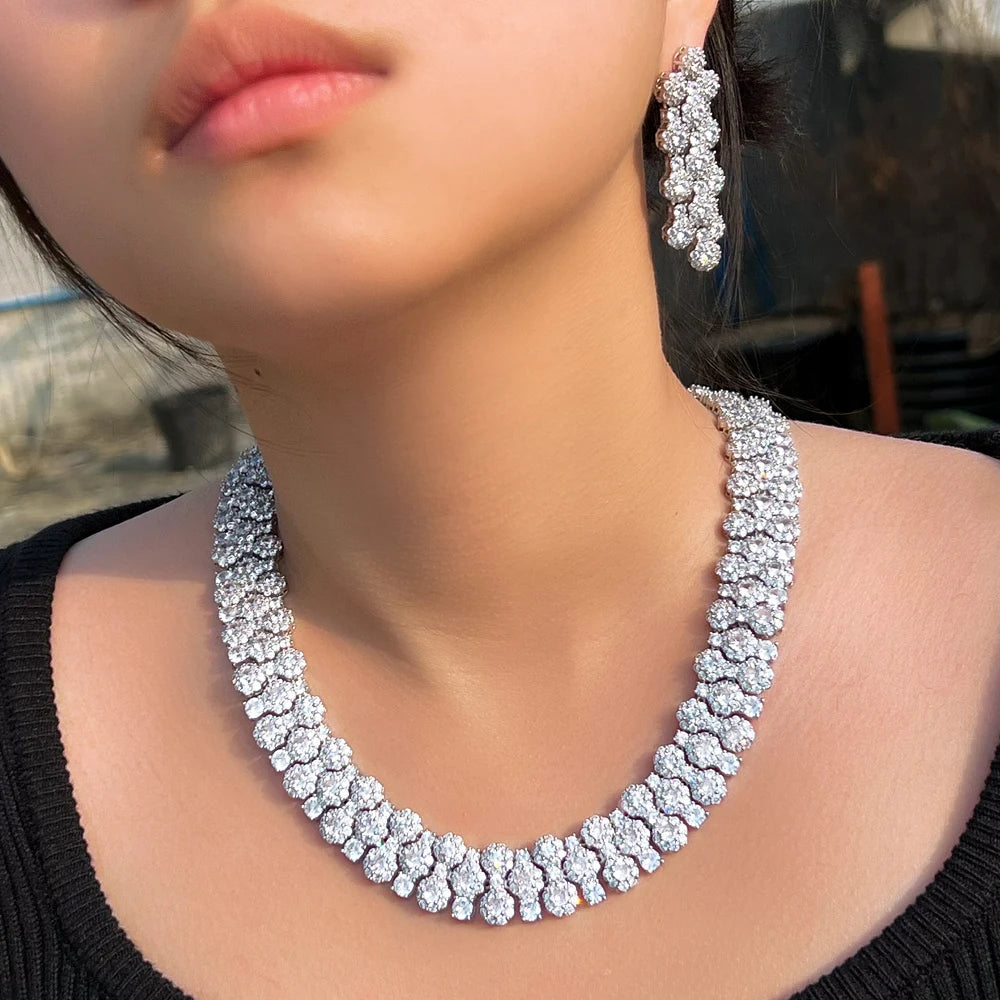 Close view of a crystal necklace and matching dangling earrings worn together