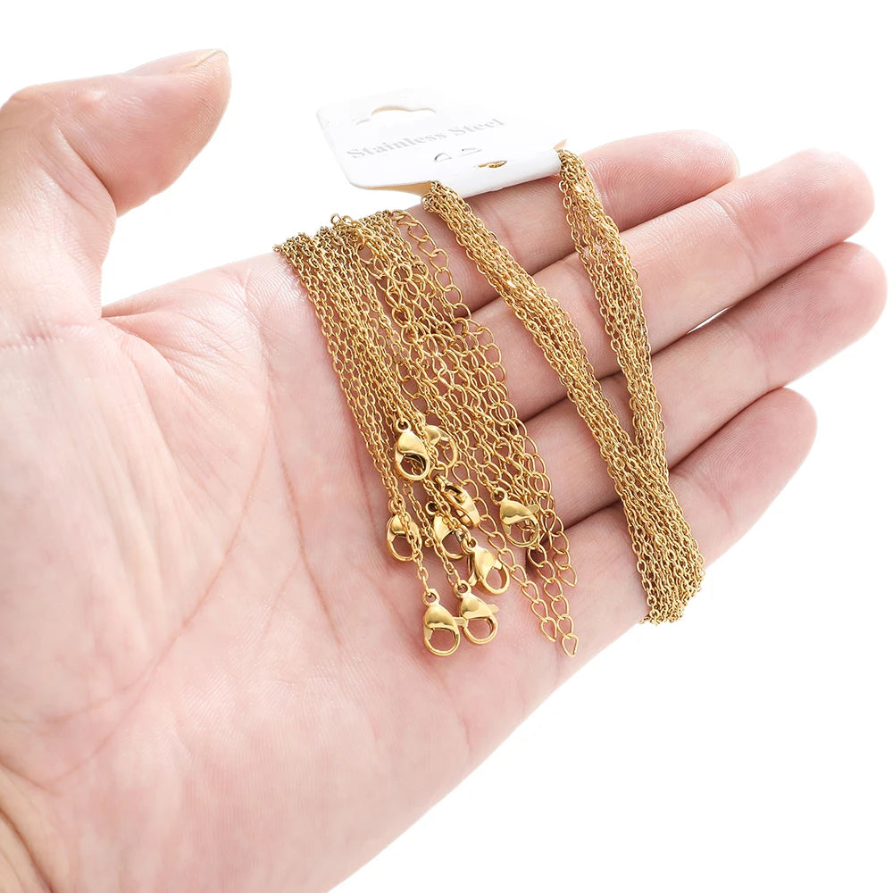 Hand holding gold cable link chain extenders set with clasp connector ends