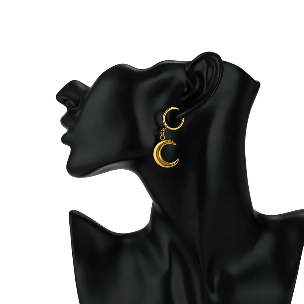 Gold-tone crescent dangle huggie earrings with loop posts on a black head form.