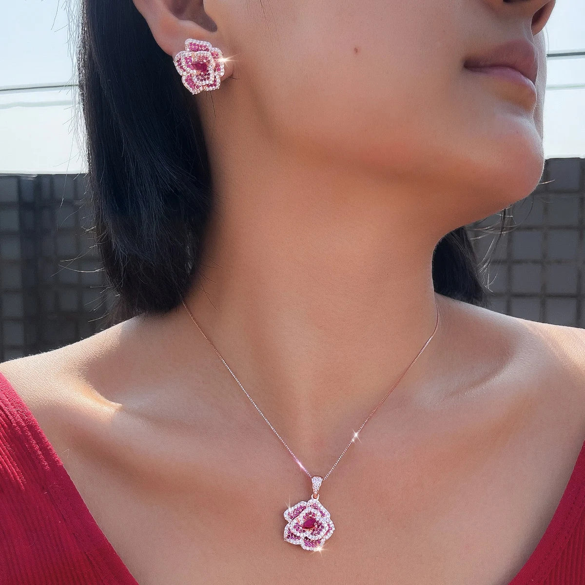 Rose-red flower CZ pendant necklace and matching earring worn on a model
